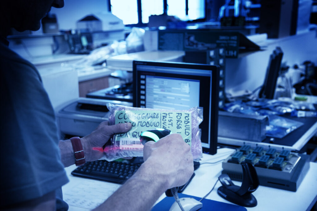 Un tecnico di Ima Servizi sta lavorando in un laboratorio elettrico per la ripazione e collaudi di stazioni di servizio.